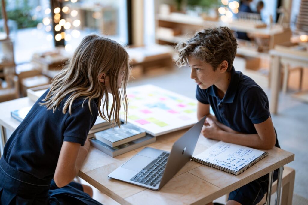 Grade 6 Montessori students in uniform collaborating on an extended research project representing high school preparation