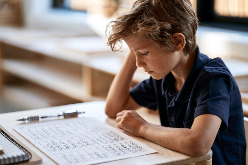 Montessori upper elementary student in uniform reviewing a modern work plan and scheduling independent tasks